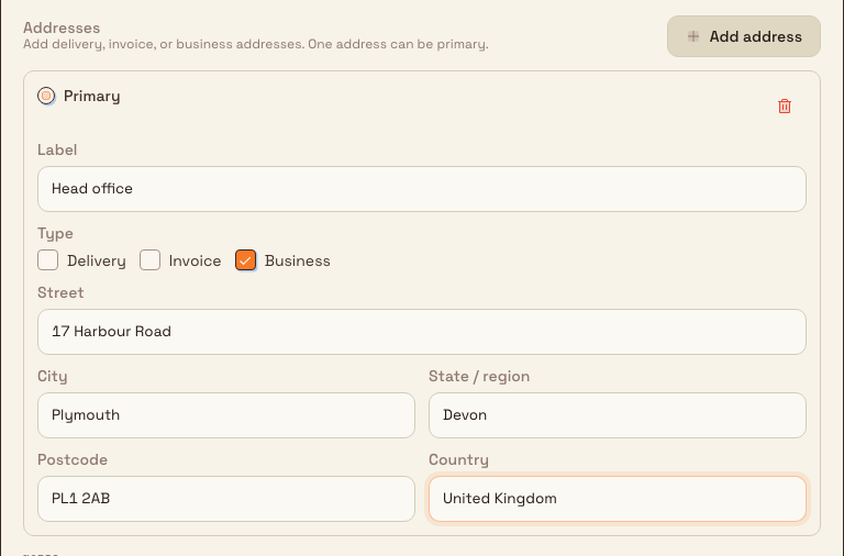 Structured customer address editor with a filled primary Business address and fields for label, street, city, region, postcode, and country.